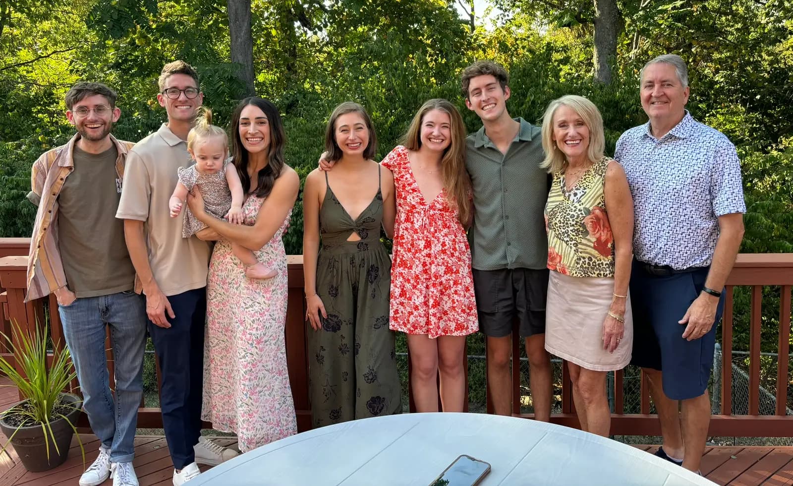 Tom Lampe, at right, with his family on a deck in a wooded backyard.